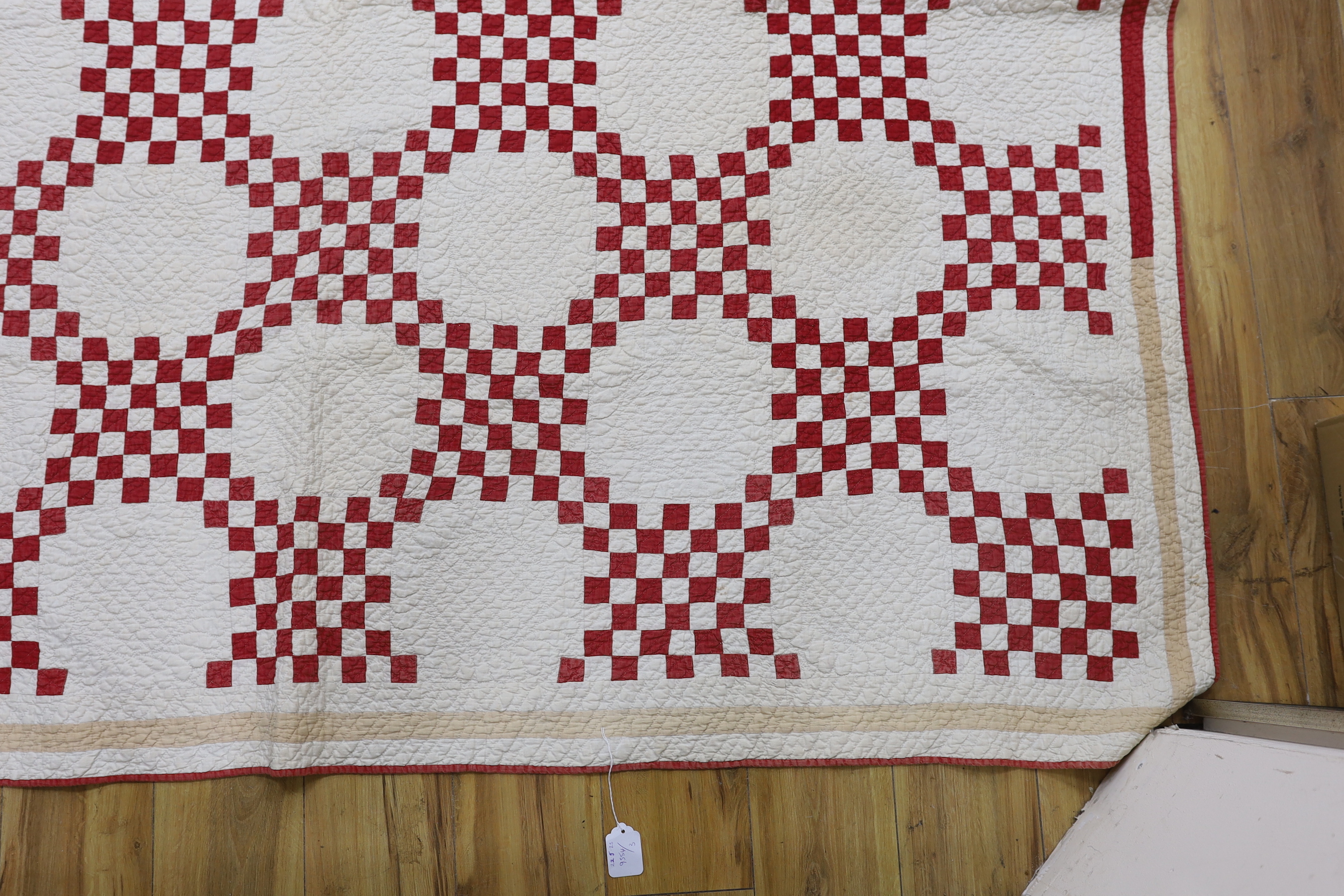 A 19th century Irish chain quilt with red and beige fabric on cream background American